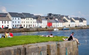 People sitting along the River Corrib in the Cladagh Area